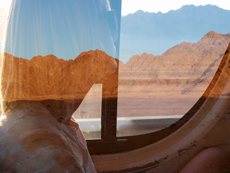 Double exposure portrait, girl dreamily looking at the mountains in the bus windowの写真素材