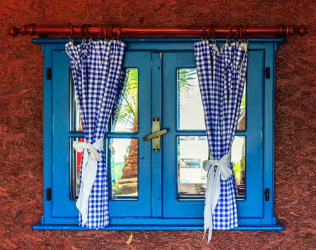 blue window with curtains in the wooden wallの写真素材