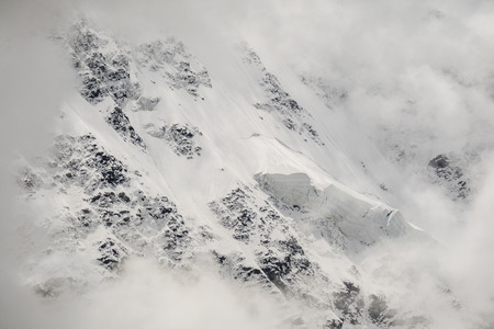 Snowy mountain peaks and green meadows and forests