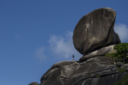 Big rocks with a little man standing on them 
