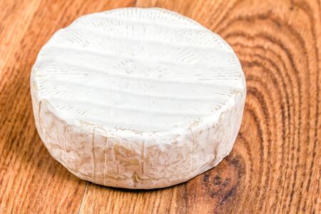 A head of brie cheese on wooden surfaceの写真素材