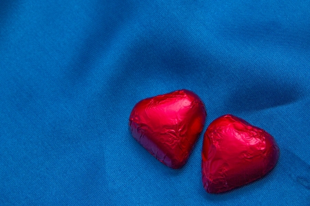 Heart shaped candies on a blue textile backgroundの写真素材