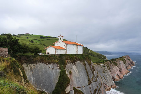San Telmo Chapel on top of cliff next to turquoise sea, Zumaia. Aerial backwardsの写真素材