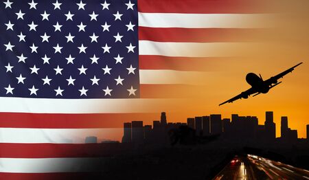 Travel and transport concept with skyline silhouette, highway traffic and airplane at sunset merged with real fabric flag of USAの写真素材