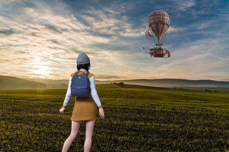 A traveling girl with a backpack watches a large balloon fly across a vast grassy plain at sunrise.3D illustration 3D renderingの写真素材