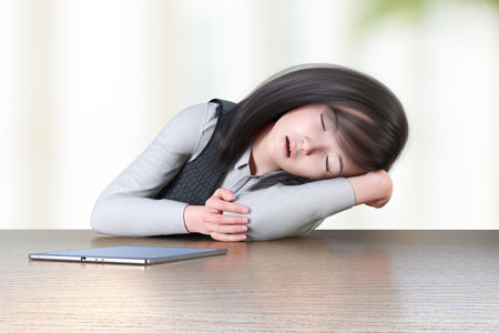 Female employee dozing off with one hand pillow at an office tableの写真素材