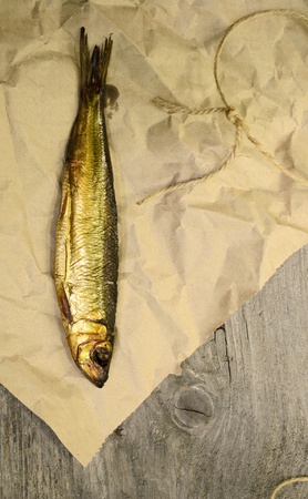 Fresh smoked baltic herring for the dinner on the wrapping paper with wooden backgroudの写真素材