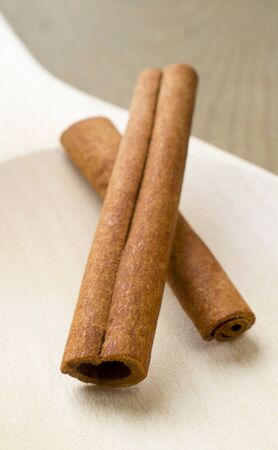 Two cinnamon sticks on wooden spoon