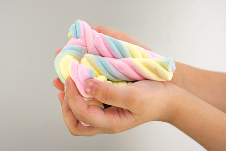 A Child's Handful of Sweet Colorful Marshmallowsの写真素材