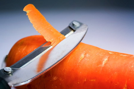 Peeler Peeling the Skin Off a Fresh Carrotの写真素材