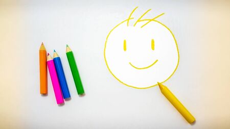 Doodle of a Smiley Face with Yellow Colored Pencilの写真素材