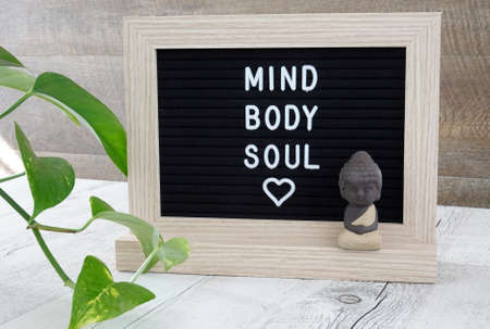 Mind body and soul lettering on letter board with cute little buddha.の写真素材