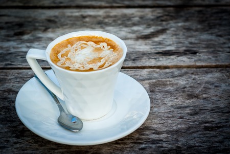 Coffee in a cup on wood backgroundの写真素材