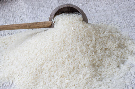 Uncooked jasmine rice in a wood bowl.の写真素材