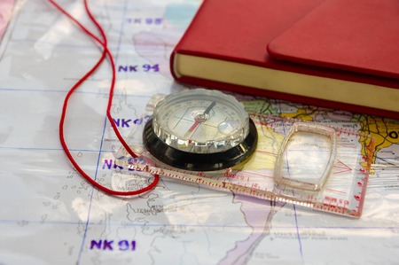 Compass and red Leather cover note book on Thailand map background.の写真素材