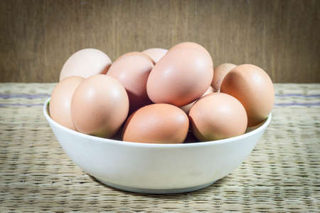 Chicken eggs in a dish on wood background.の写真素材
