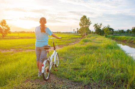 woman with bicycle countryside in summer.