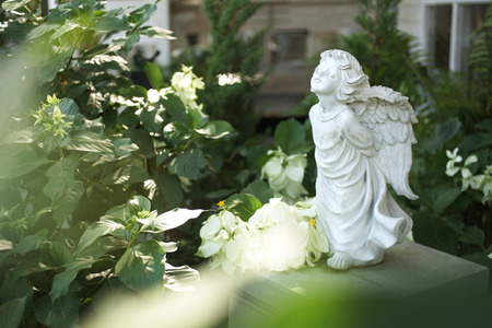 close up stone angel doll in gardenの写真素材