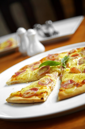 close up salami and sausage pizza in white dishの写真素材