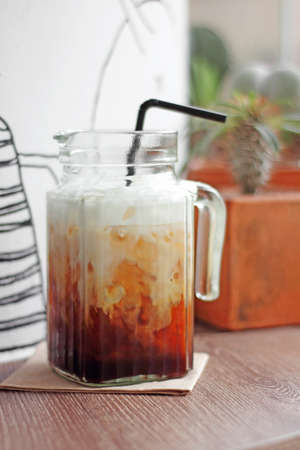 close up cold cappuccino on wooden tableの写真素材