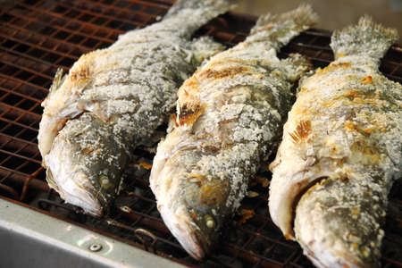 thai fish grilled with herb in iron trayの写真素材