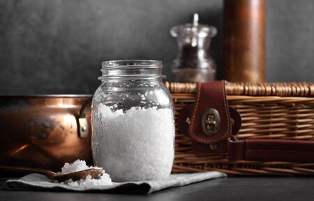 sea salt in glass bottle and spoon on kitchen rustic style