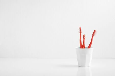 Group of red toothbrush in a plastic cup with a blank space for a text, toothbrush in bathroomの写真素材