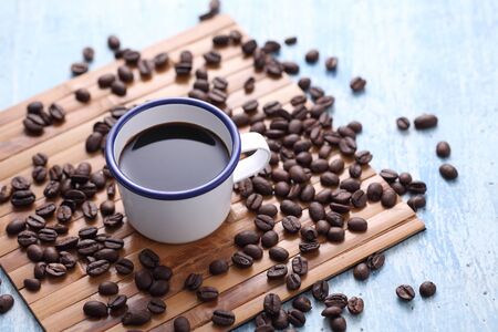 Coffee in cup and coffee bean on rustic table with a blank space for a text, Espresso in cup on blue...