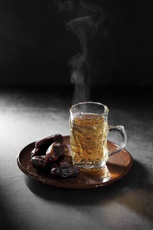 Arab tea and dates fruit  on a concrete background with a blank space for a textの写真素材