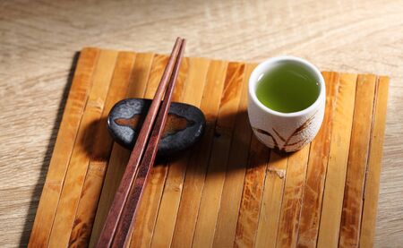 Chopsticks and green tea on wooden table, Japanese utensil in rustic backgroundsの写真素材