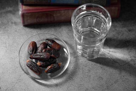 dates fruit and Islamic Book Koran on a concrete background, Islamic background in ramadanの写真素材