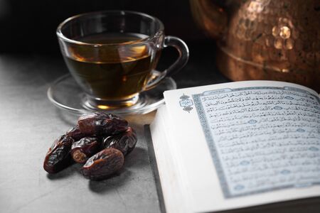dates fruit and Islamic Book Koran on a concrete background, Islamic background in ramadanの写真素材