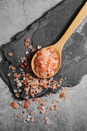 Himalayan pink salt in wooden spoon on loft backgroundの写真素材