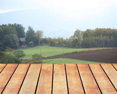 Empty wooden table with countryside backgroundの写真素材