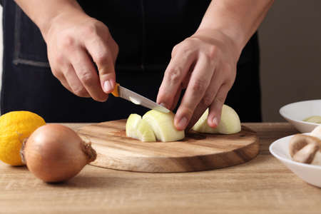 Chef chopped onions on wooden cutting board in kitchenの写真素材