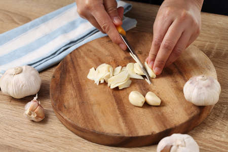 Chef chopped garlic on wooden cutting board in kitchenの写真素材