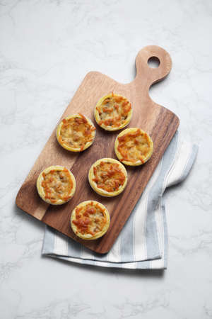 Mini pie from meat and mushrooms in wooden tray on marble backgroundの写真素材
