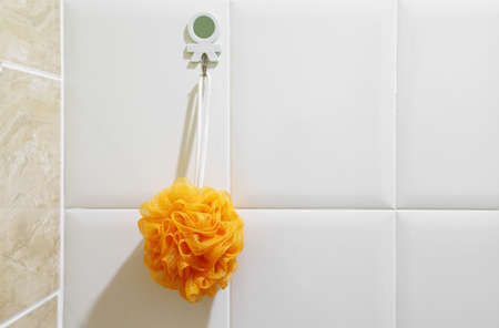Orange sponge for shower hang in bathroomの写真素材