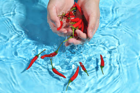 Woman hand washing bird pepper in clean water. Wash vegetables before cooking