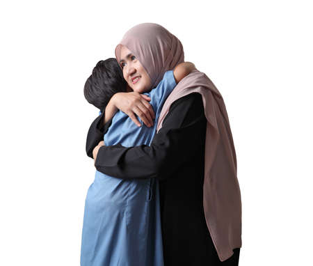 Young Muslim woman hugging and smiling with her little son isolated on white backgroundの写真素材