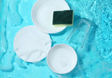 Dishware and sponge in clean water. Wash utensil after used.の写真素材