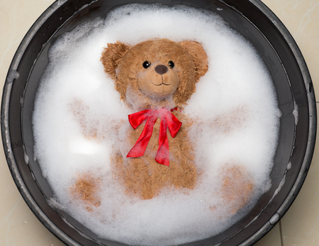 Brown toy Bear taking a bath for relax concept.の写真素材