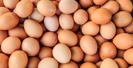 Brown chicken eggs for sale at a market for background.の写真素材