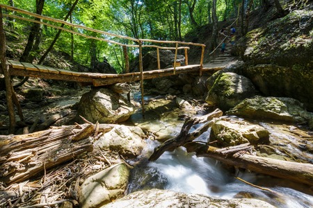 Wooden bridge through the forest river. Crimea, Russiaの写真素材