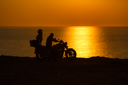 Two people in the motorcycle at sunset on the Black Sea, Crimeaの写真素材
