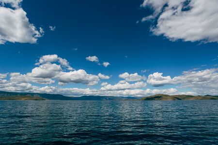 Heavy clouds over blue lake baikal, russiaの写真素材
