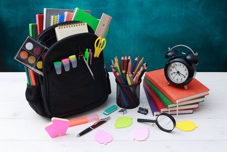 Back to school concept. School bag, pencils, crayons, scissor, notebooks, alarm clock, eraser,...