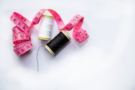 Spools of thread and measuring tape on a white background. Sewing concept