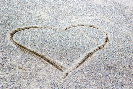 Heart drawn in the sand on the beach. Valentine's day background.の写真素材