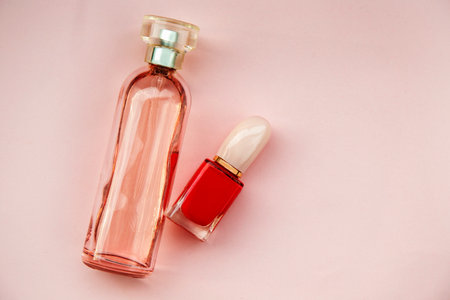 Bottle of perfume and nail polish on a pink background. Flat lay, top view.の写真素材